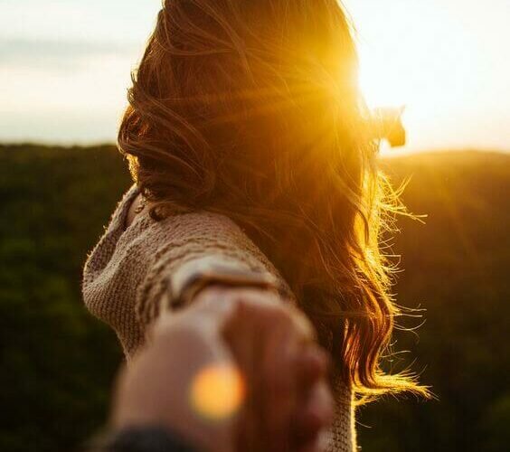 mulher-dando-mao-por-do-sol