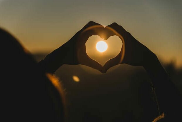 maos-que-fazem-a-forma-de-um-coracao-com-o-sol-no-meio